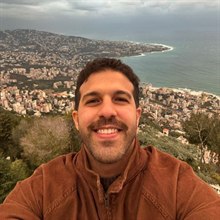 Ahmed Khaled, smiling, with a coastline behind him.